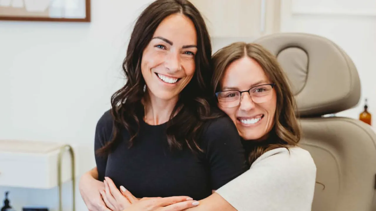 Clare Bourdon and Brooke Conrady embracing beside the treatment chair at Pomalo Wellness.