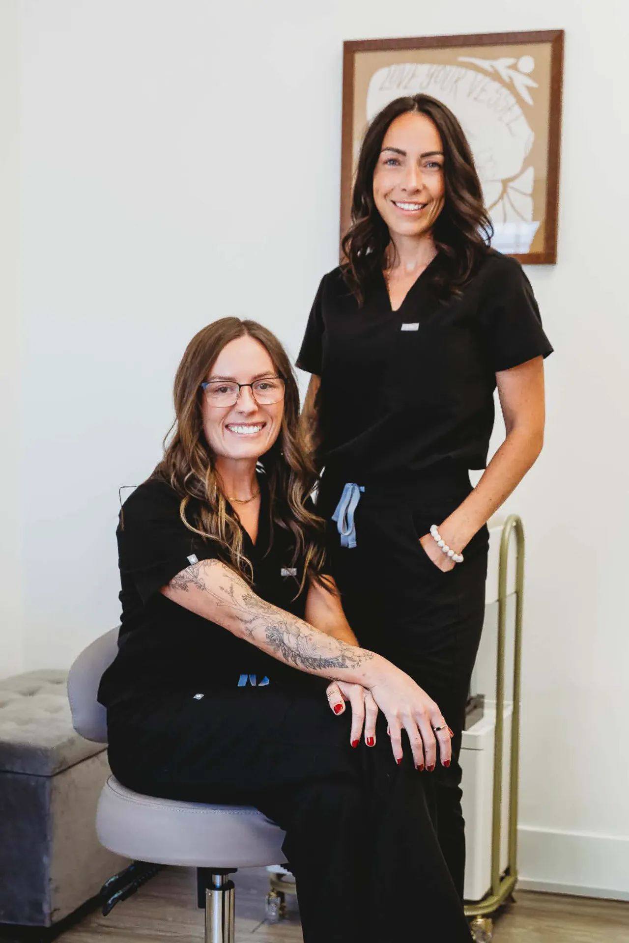 Clare Bourdon and Brooke Conrady smiling together in the treatment room at Pomalo Wellness.